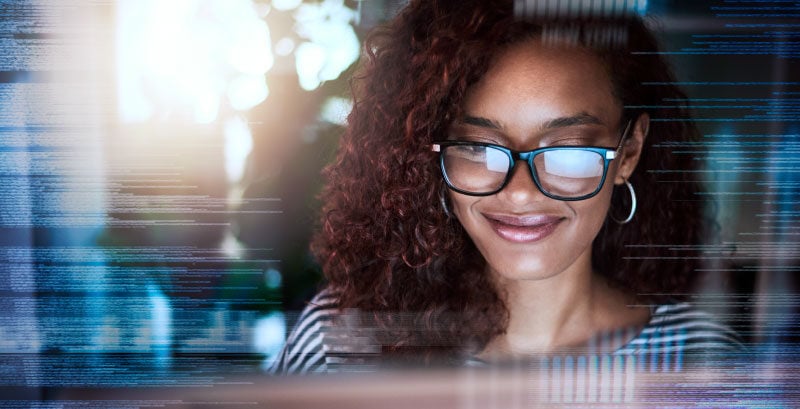 Woman with monitor reflected in her glasses